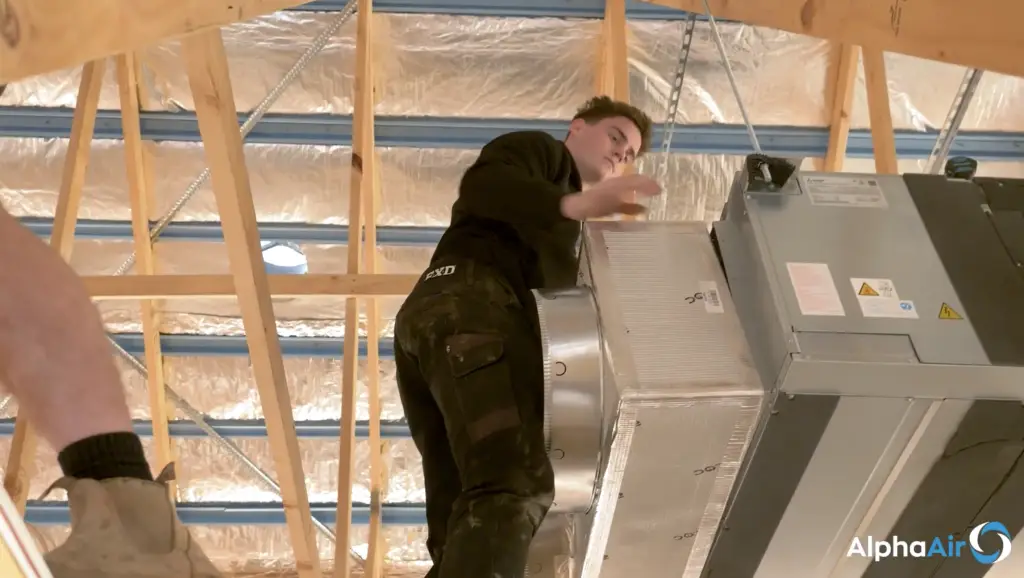 Installing ducted heating and cooling unit into roof.