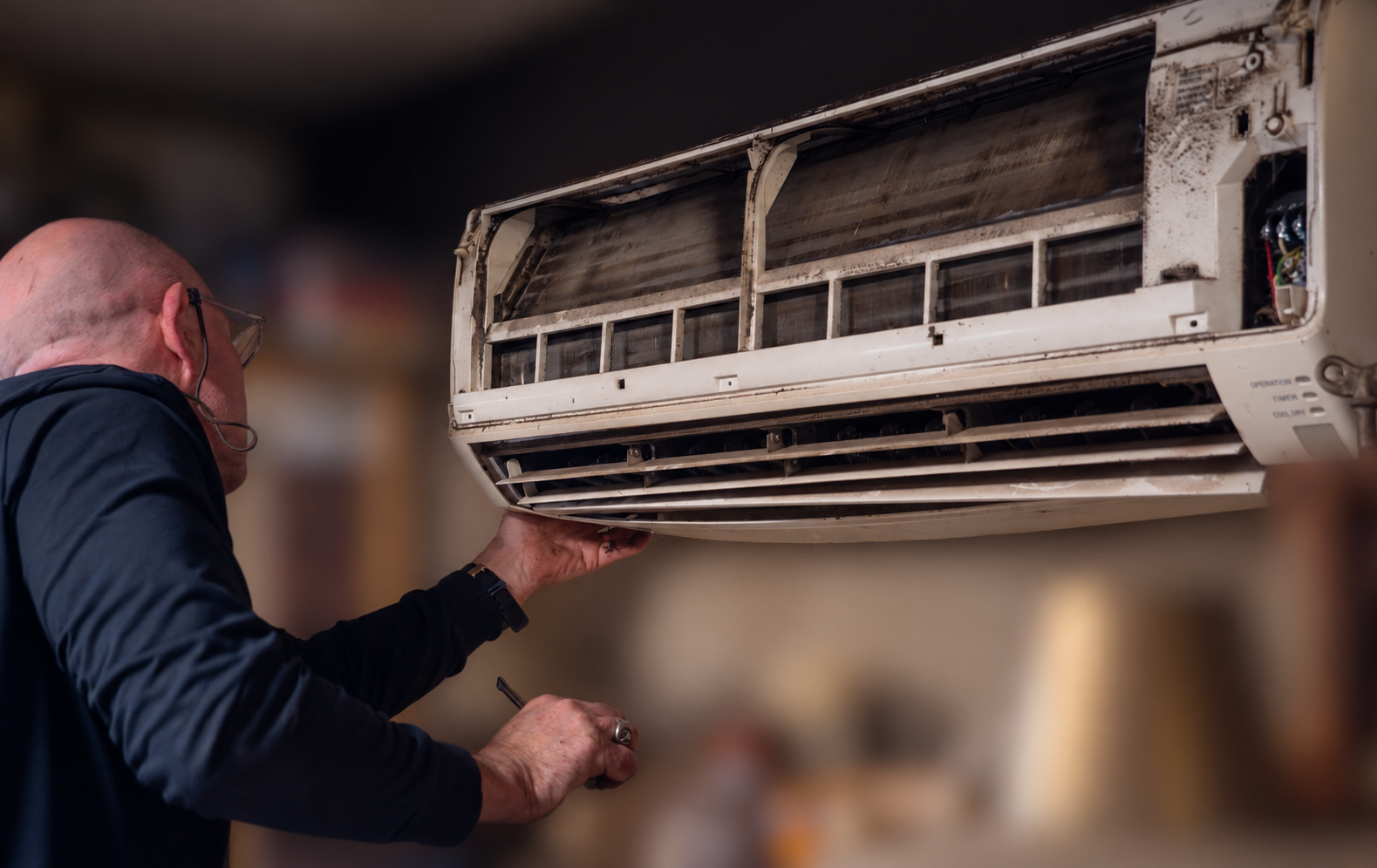 Alpha Air technician opening a split system for cleaning